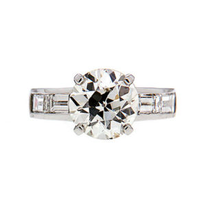 Round brilliant diamond engagement ring with channel set diamond baguettes