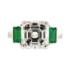 Asscher cut diamond engagement ring with emerald side stones